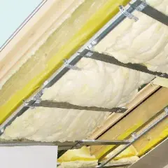 Montaż folii paroizolacyjnej na poddaszu. Widoczna wełna mineralna, profile aluminiowe i żółta folia.