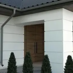 Nowoczesna elewacja z białymi boniami i drewnianymi akcentami. Eleganckie bonie na elewacji podkreślają geometryczny charakter budynku.