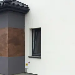 Eleganckie tynki wapienne imitujące drewno zdobią fragmenty nowoczesnego domu.