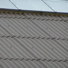 Faliste pokrycie dachowe, przypominające eurofala, w odcieniu szarości. Widoczne są drobne punkty mocujące.